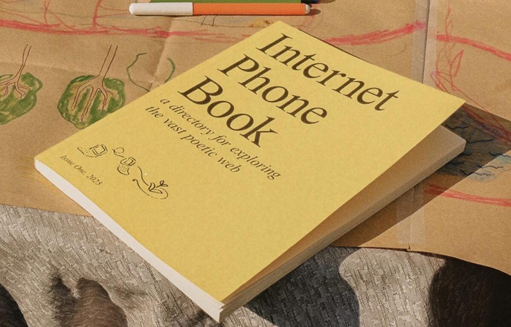 A yellow book with the title - Internet Phone Book - on a table with crayon drawings behind it.